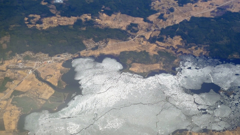 Nous survolons les fjords où la mer est encore prise par les glaces et les sommets très enneigés. Vol Oslo - îles Lofoten