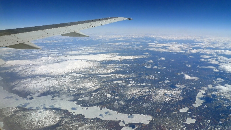 Nous survolons les fjords où la mer est encore prise par les glaces et les sommets très enneigés. Vol Oslo - îles Lofoten
