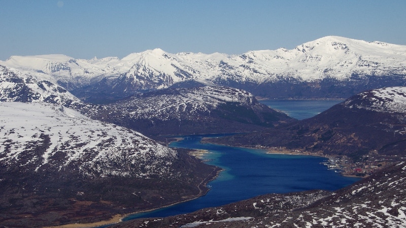 Nous survolons les fjords où la mer est encore prise par les glaces et les sommets très enneigés. Vol Oslo - îles Lofoten